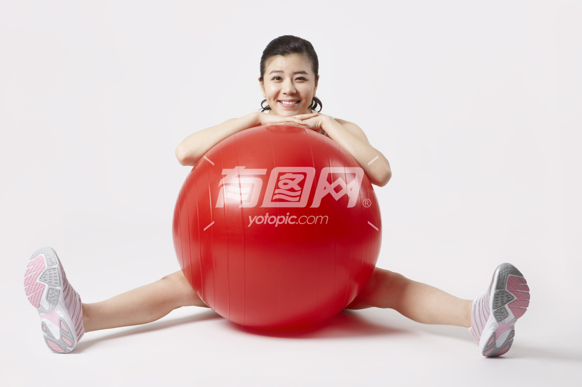 年轻女子在锻炼瑜伽球的图片