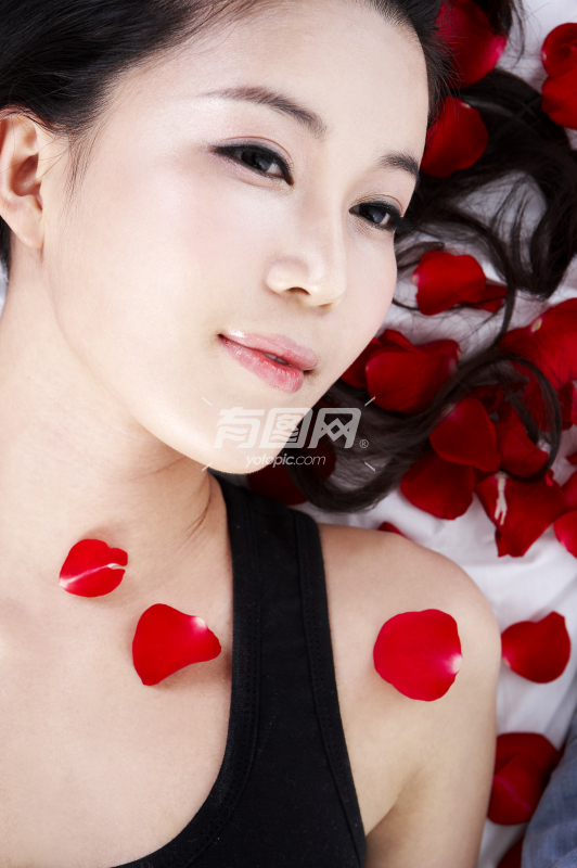 躺在玫瑰花瓣上的女人