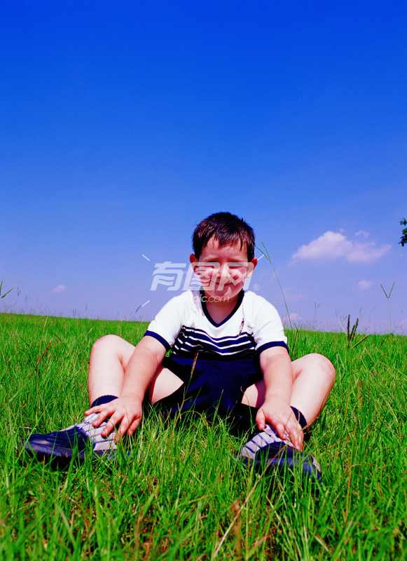 坐在草地上的小男孩