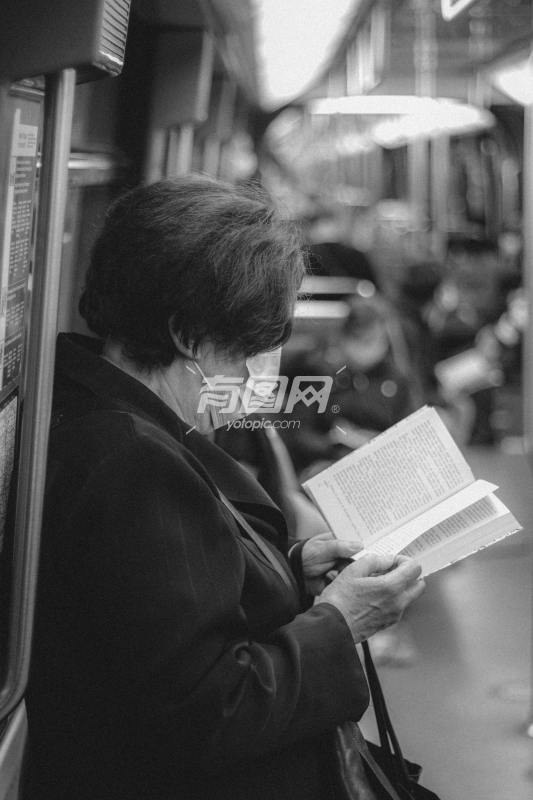在地铁看书的老人
