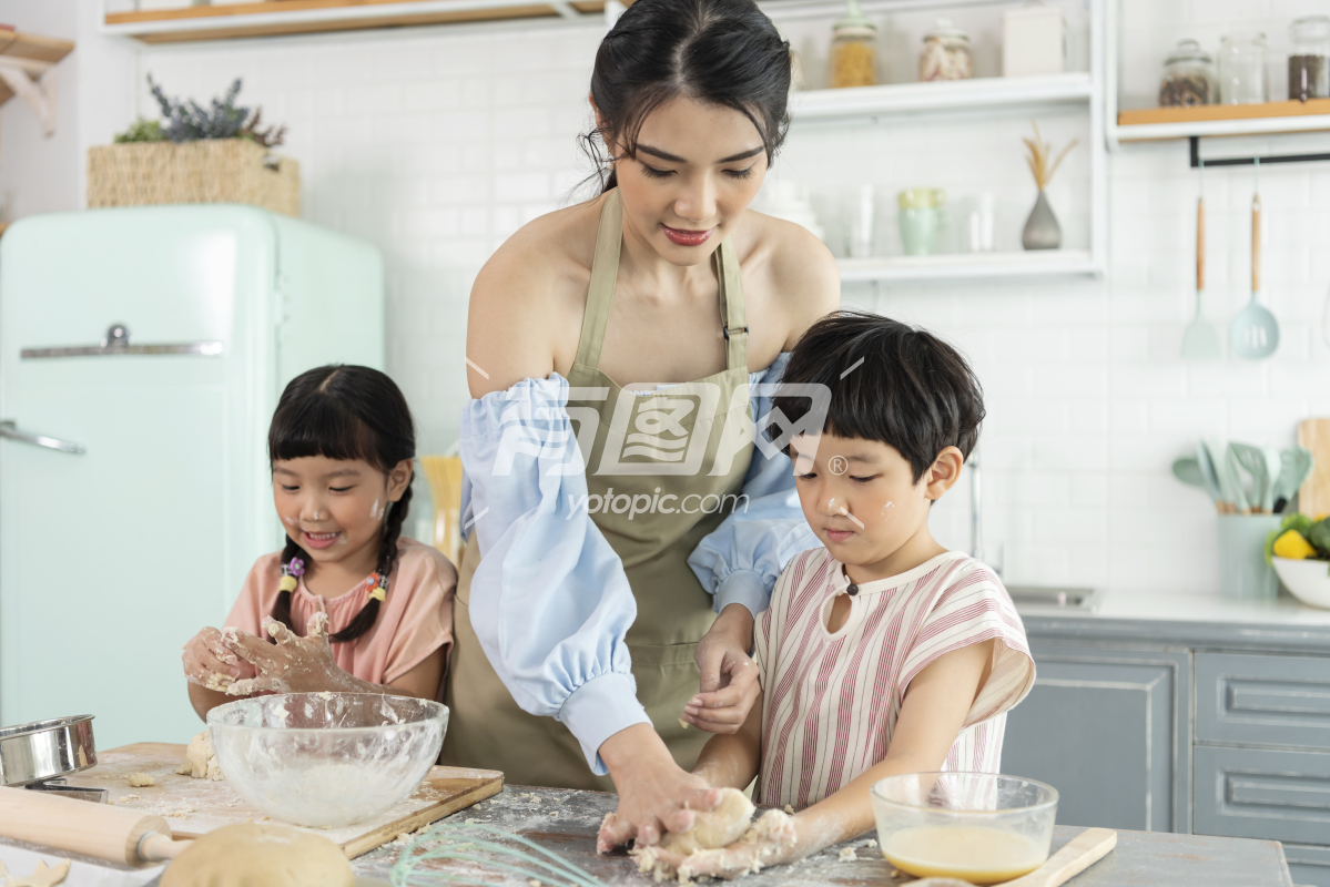 女人教两个孩子制作食物