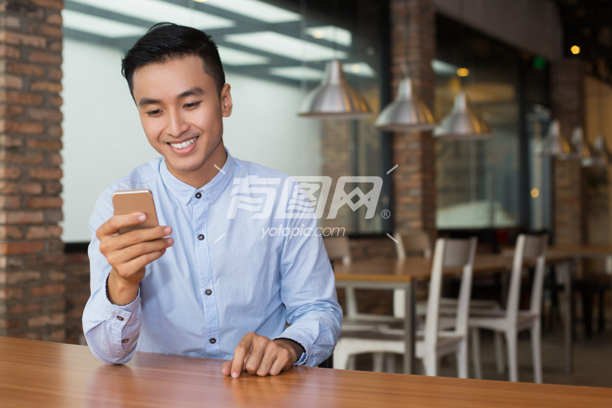 微笑的亚洲男子使用智能手机