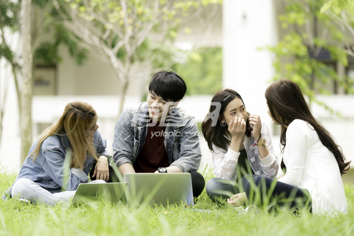 亚洲大学生在草坪上聊天