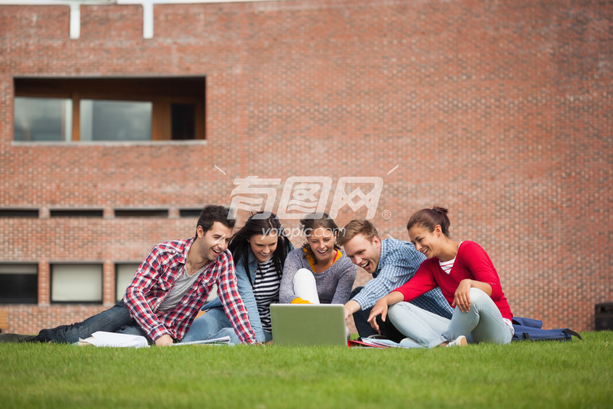 大学生坐在草坪上讨论