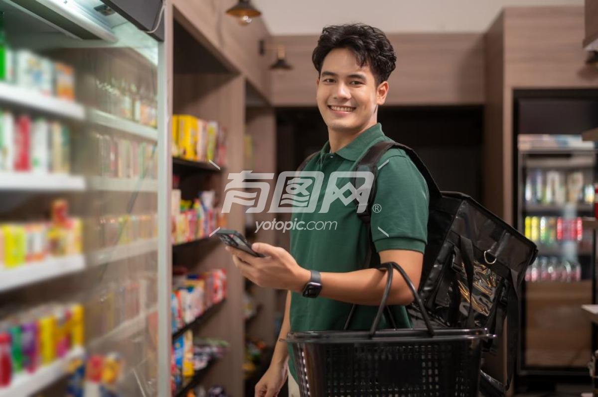 年轻的亚洲男子在超市购物